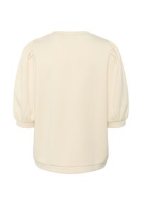 Krämfärgad topp med puffärmar och rund halsringning. Slät textur med subtil glans, med en böjd nederkant och rynkade detaljer.