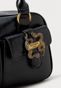 Black faux leather handbag featuring a gold snake-shaped accent and a rectangular plate with "JUST CAVALLI MILANO" engraved.