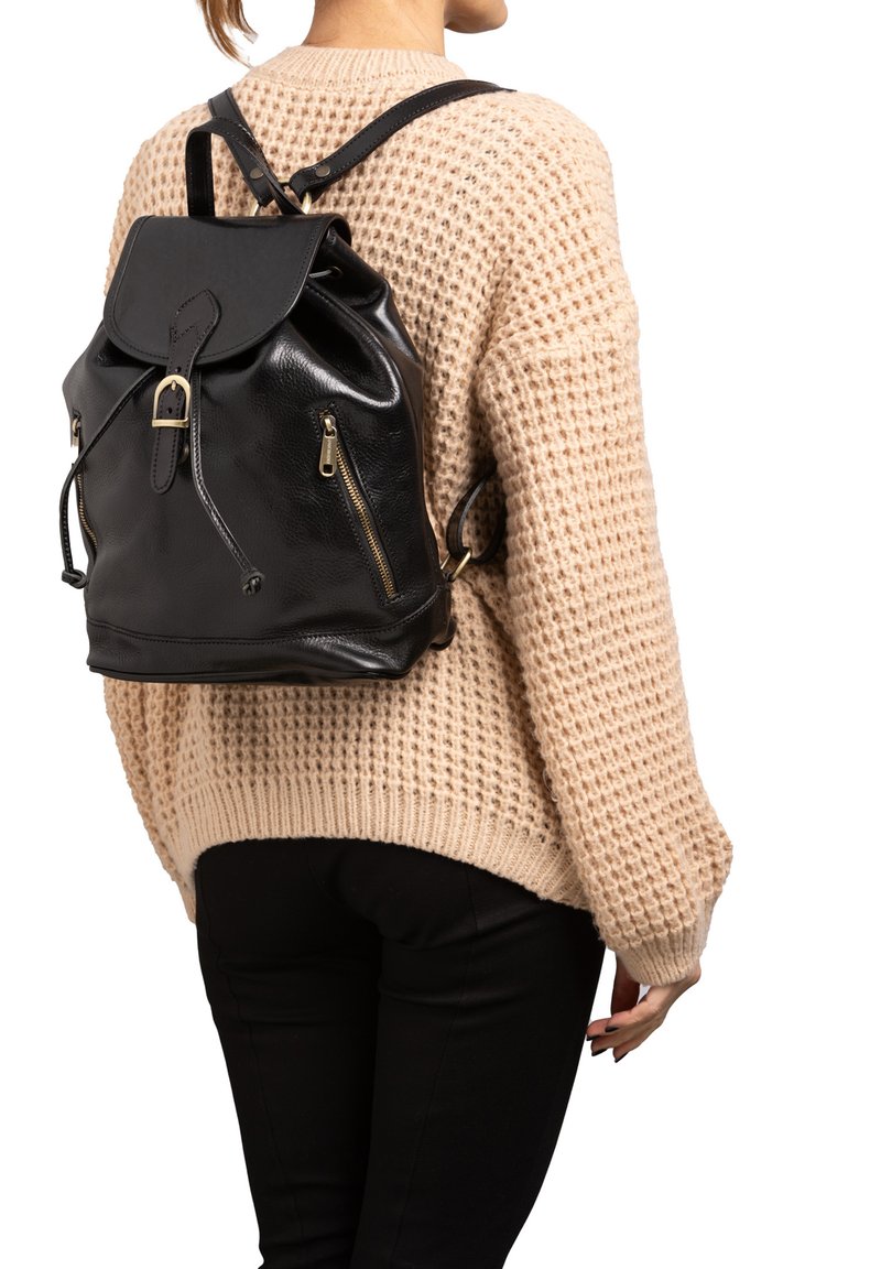 Zwarte leren rugzak met verstelbare banden, ritszakken en een omgevouwen klep. Gestructureerde afwerking met gouden hardware accenten.