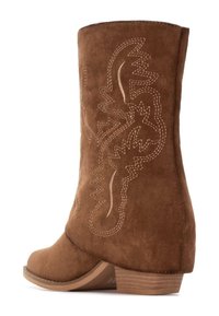 Stivaletti in suede marrone alla caviglia con una parte superiore curvata, caratterizzati da motivi di cucitura intricati e un tacco impilato per maggiore stabilità e dettaglio di design.