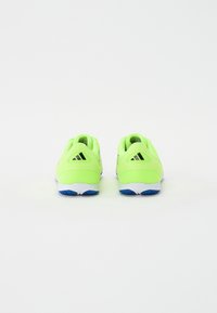 Zapatillas deportivas de color verde brillante con parte superior de malla texturizada, suelas blancas y acentos en azul. Incluyen un logotipo y un cuello de tobillo acolchado.