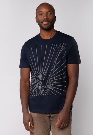 Navy T-shirt met een gouden grafisch ontwerp van een muziekinstrument met radiale lijnen, gemaakt van een katoenmix voor comfort.
