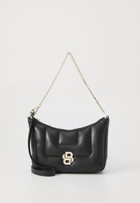 Sac à main en cuir noir avec une bandoulière en chaîne dorée, fermeture éclair et un accent logo doré à l'avant. Texture douce et matelassée.