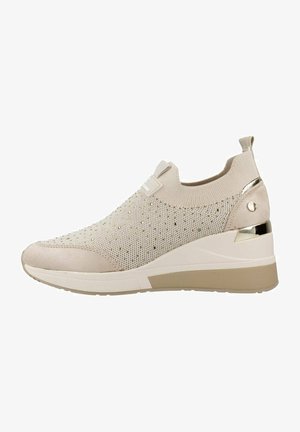 Zapatillas slip-on beige con parte superior de punto, que presentan acentos metálicos, una punta texturizada y una suela de cuña con un sutil diseño gris.