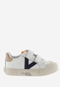 Sneaker bianco con cinturini in velcro, logo blu navy, accentuazione del tallone beige, suola in gomma testurizzata e dettaglio arancione vicino alla linguetta.