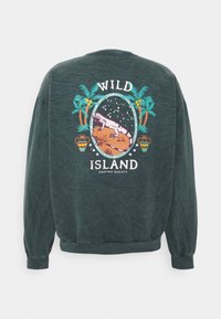 Sudadera de color verde oscuro con escote de cuello redondo. Presenta un gráfico colorido de palmeras, un lagarto y el texto "WILD ISLAND" en la parte posterior.
