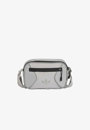 Hellgraue Adidas Schultertasche mit schwarzer Reißverschlusstasche vorne und verstellbarem Schulterriemen.