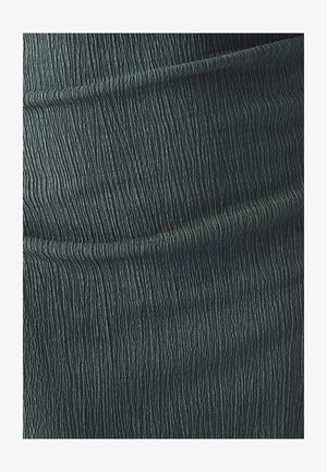 Tela verde texturizada con un patrón de estrías, que presenta líneas verticales creando un efecto de olas. Material suave y fluido.