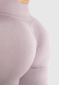 Leggings viola chiaro con un design aderente e una texture liscia, caratterizzati da una vita alta e dettagli arricciati sul retro.