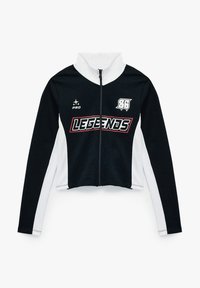 Chaqueta con cremallera recortada en blanco y negro, que presenta un alto collar, mangas largas y la palabra "LEGENDS" en letras negritas a lo largo del pecho.