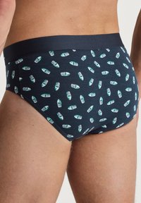 Herenondergoed in donker marineblauw katoenmix met een all-over print van groene en witte boten; elastische tailleband, aansluitend ontwerp, gladde textuur.