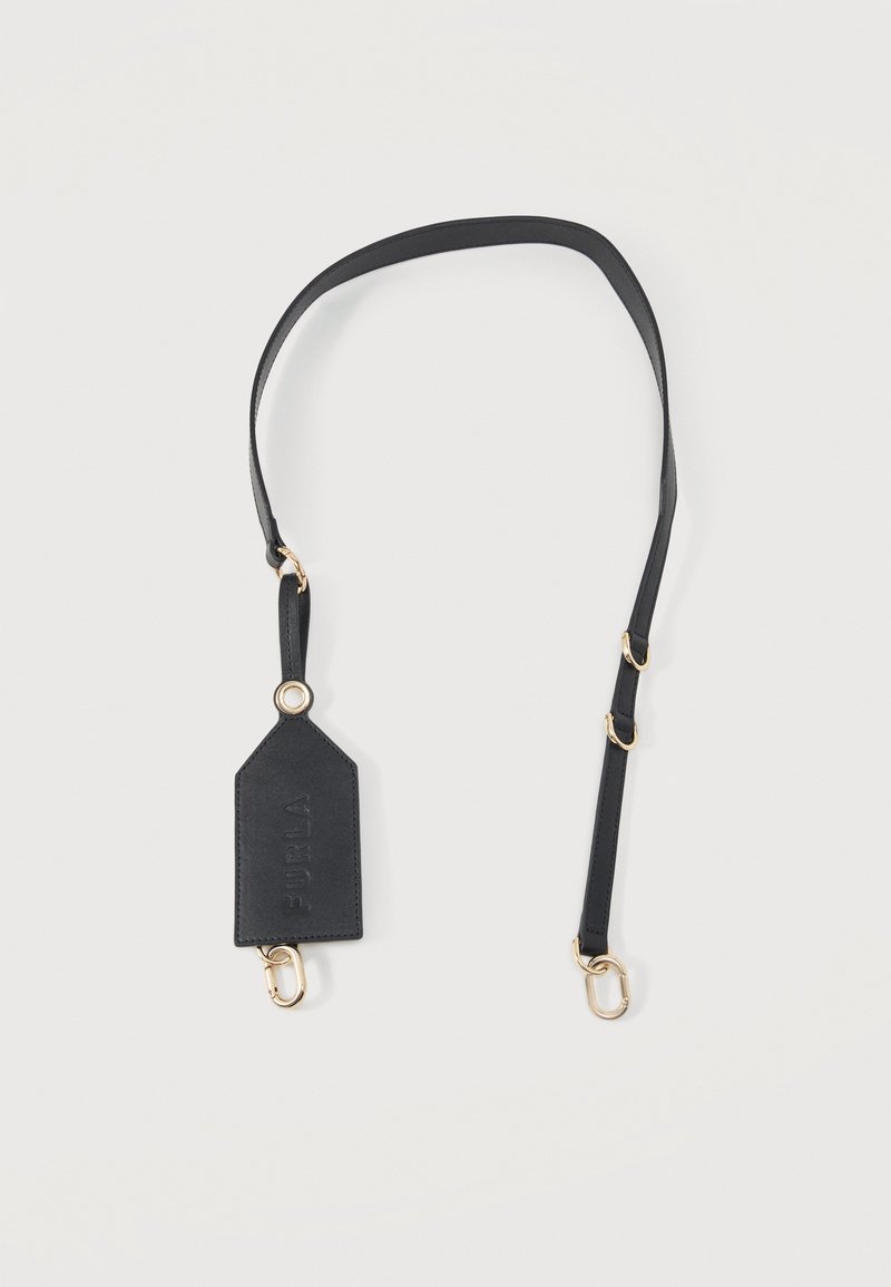 Bandoulière de sac en cuir noir réglable avec fermoirs dorés et une étiquette rectangulaire embossée du nom de la marque « Furla » sur fond blanc.