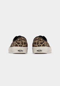 Ζευγάρι παπουτσιών Vans χαμηλού τύπου με καφέ και μαύρο λεοπάρ μοτίβο, λευκές λαστιχένιες σόλες και λογότυπο "Vans Off The Wall" στην ταμπέλα της φτέρνας.