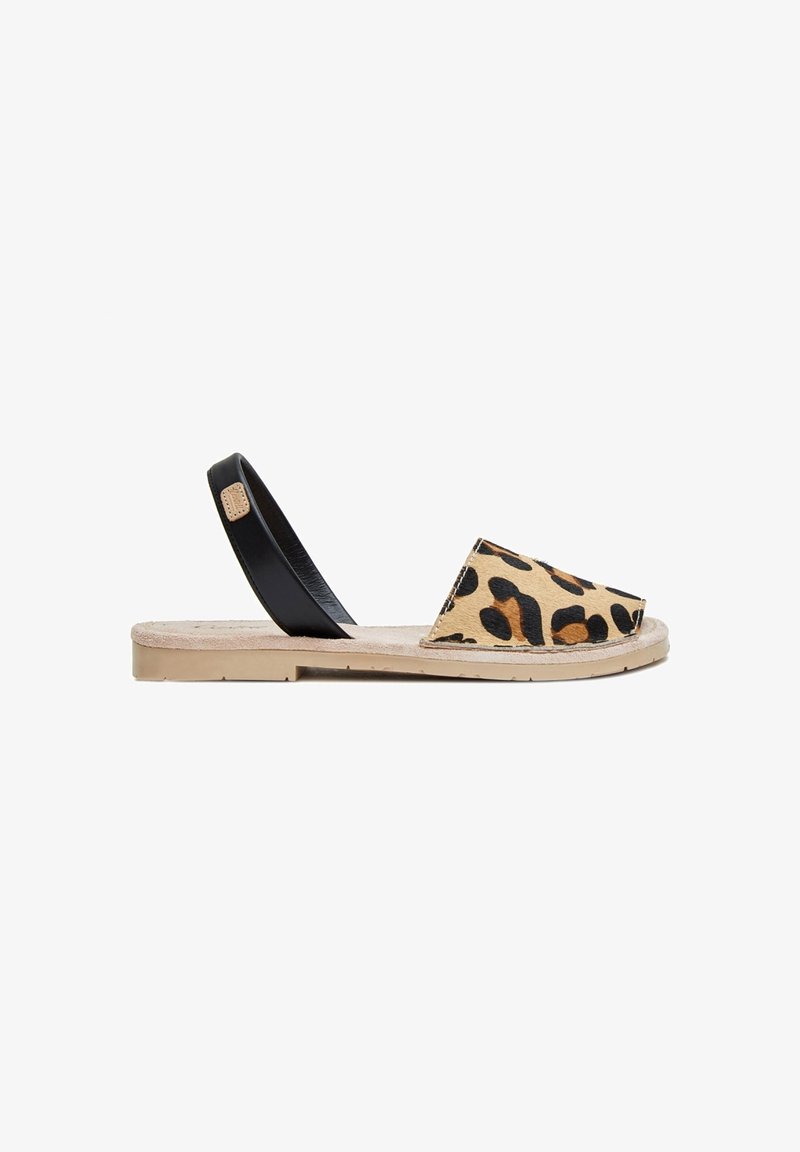 Sandalia de estampado de leopardo con tira sintética negra, suela plana y parte superior de textil. Presenta punta redondeada y un diseño minimalista.