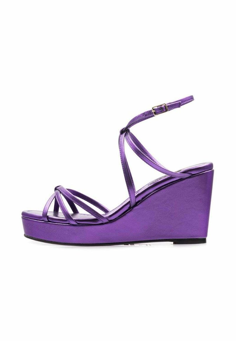 Sandalias de cuña moradas con finas tiras entrelazadas, un acabado metálico suave y una base de plataforma para mayor altura. Cierre con hebilla en el tobillo.