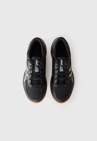 Black athletic shoes with a mesh upper, silver accents, and a rubber outsole. Features laces and a branded tongue label.