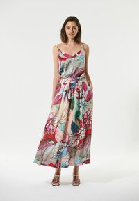 Robe maxi en coton à fleurs avec un décolleté en V, des bretelles ajustables et une taille élastique. Présente des feuilles et des fleurs colorées sur un fond clair.