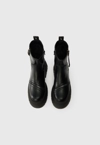 Černé kožené kotníkové boty s hladkým povrchem, diagonálním zipem, kulatou špičkou, texturovanou podešví a úchyty na zadní straně.