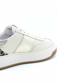 Baskets en cuir beige avec des accents texturés marron, finition lisse, détails cousus et semelle en caoutchouc blanc. Fermeture à lacets.