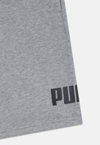 Calções de algodão cinza com uma textura suave e uma cintura elástica, apresentando um logo preto "PUMA" impresso na lateral.