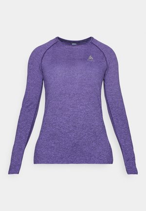 Paarse lange mouwen sportshirt met een gestructureerd patroon, ronde halslijn en raglanmouwen. Klein logo op de bovenkant van de linkerborst.