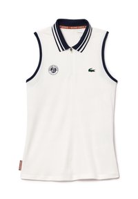 Top polo sans manches blanc avec un col rayé bleu marine, fermeture éclaire à l'avant et logo de crocodile vert. Présente une marque Roland Garros sur la manche.