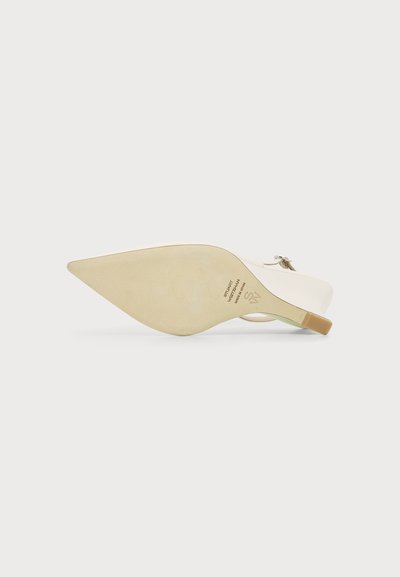 Chaussure slingback beige à bout pointu avec un petit talon, montrée de côté côté semelle sur un fond clair uni.