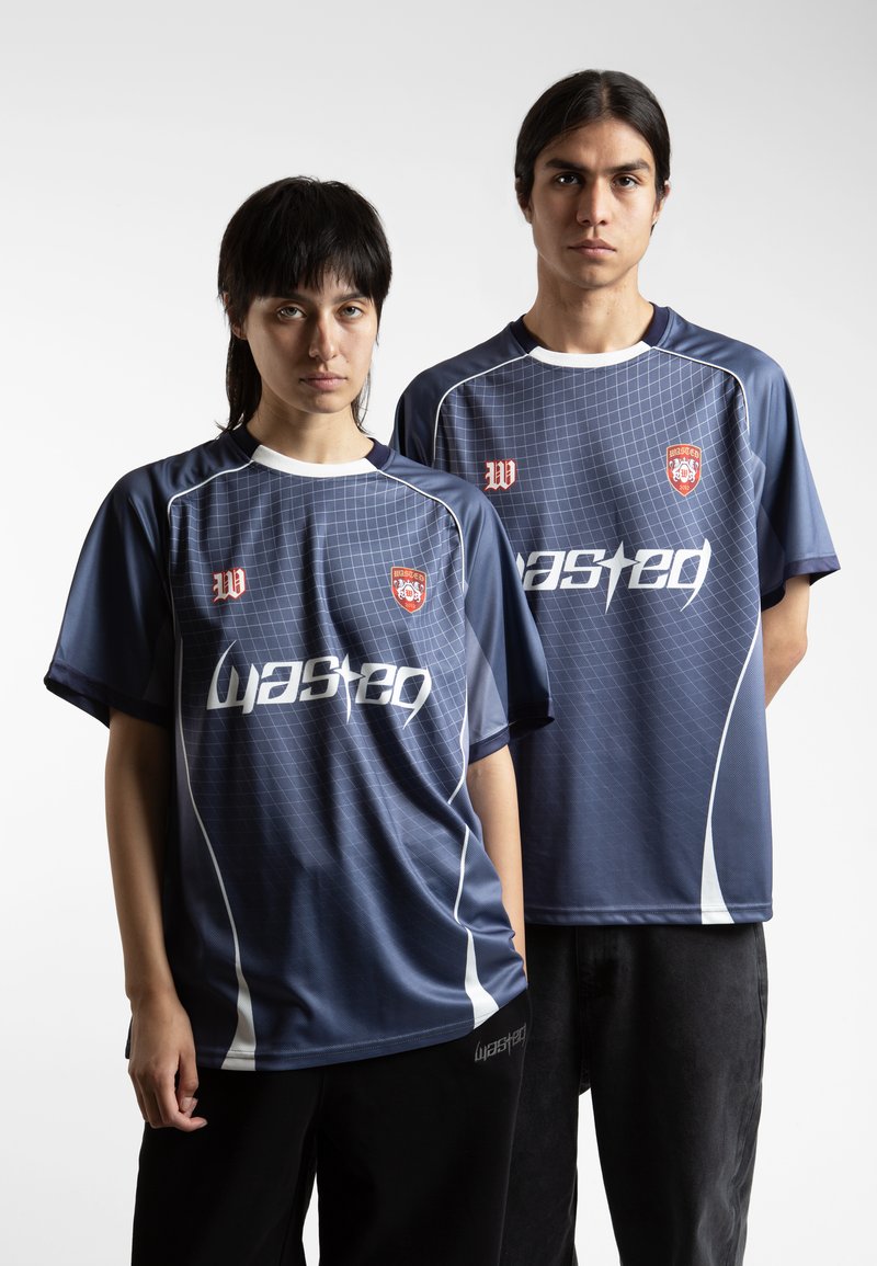 Jūras zila sporta krekli ar režģa rakstu, baltām akcentiem un "Wasted" logo. Audums izskatās gluds; brīva piegriezuma dizains komfortam.