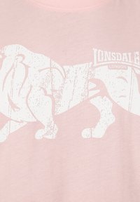 Gaiši rozā T-krekls ar lielu baltu lionu grafiku un uzrakstu "Lonsdale London." Gluda tekstūra ar klasisku apaļu kakla dizainu.