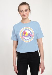 Ljusblå bomulls-t-shirt med en rund grafik av f�ärgglada cartoon-björnar och texten "självomsorgsklubb." Korta ärmar, avslappnad passform.