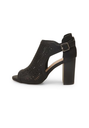 Black heeled sandal with perforated leather upper, open toe design, adjustable ankle strap, and chunky, textured heel.