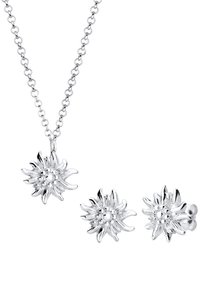 Silbernes Schmuckset mit einer blühenden Anhängerhalskette und passenden Blumen-Stud-Ohrringen. Aufwendige Blütenblattdetails und Textur.