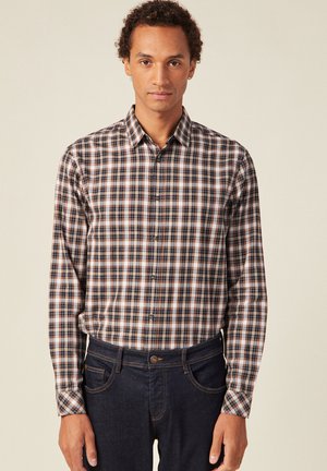 Geruite button-up shirt in een katoenmix; kleuren zijn marineblauw, wit en roest. Lange mouwen en klassieke kraag, gecombineerd met donkere spijkerbroek.