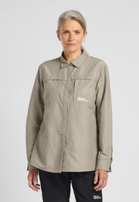 Helle khaki-langärmelige Button-Down-Bluse, mit zwei Brusttaschen, einem klassischen Kragen und einem Logo auf der linken Seite, aus glattem Material.