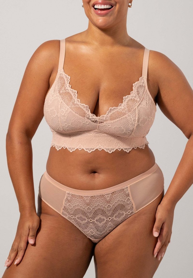 Kant beha en bijpassende hooggevlogen slip in een zachte nude kleur. Bloemige kantdetails met gladde stofpanelen, voorzien van verstelbare schouderbandjes.