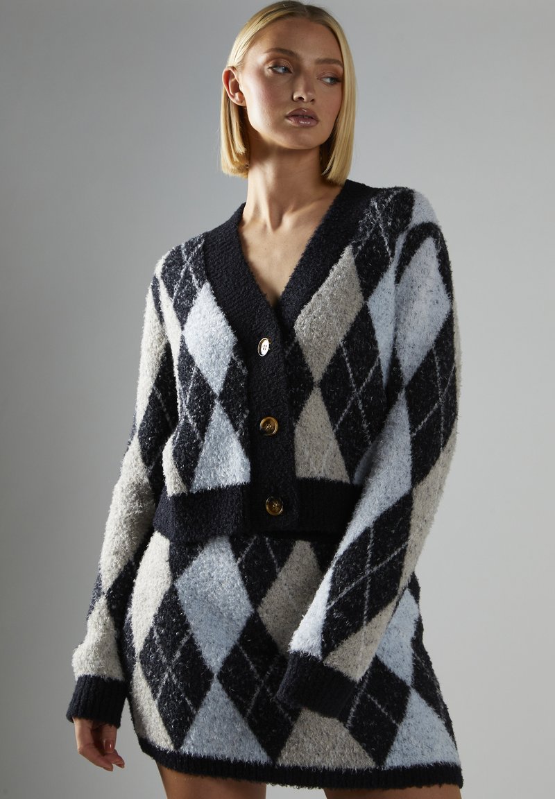 Argyle cardigan i marineblå, lys grå og himmelblå; fluffy tekstur, knaplukning, cropped pasform og brede ærmer.