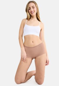 Lätt vit bomulls-camisole och beige hipster-shorts med spetsdetaljer, med sömlös design och mjuk textur, samt diskret logotypdetalj.