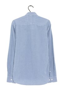 Chemise à manches longues à carreaux bleus avec un col boutonné, boutons blancs aux poignets et sur la patte de boutonnage, en tissu coton texturé, suspendue à un crochet noir.