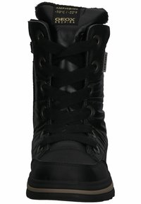Bottes de cheville noires imperméables avec une finition brillante, dotées de lacets ronds, d'œillets en métal et d'un col rembourré pour le confort.