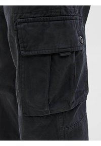 Pantalon cargo noir avec plusieurs poches, en tissu durable et au design structuré. Dispose d'une fermeture à bouton et de détails cousus sur les coutures.