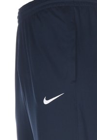 Granatowe spodenki sportowe z lekkiego materiału, z białym logo Nike po lewej stronie i elastycznym pasem.
