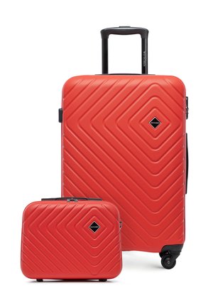 Valigia rigida rossa con manico telescopico e una custodia rigida più piccola coordinata, entrambe caratterizzate da motivi geometrici diagonali e accenti neri.