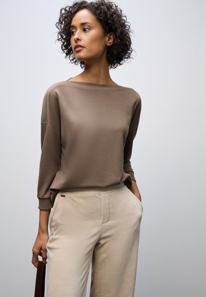 Brown, long-sleeve sweater with a wide neckline paired with beige corduroy pants. Smooth texture, relaxed fit, and subtle design details.