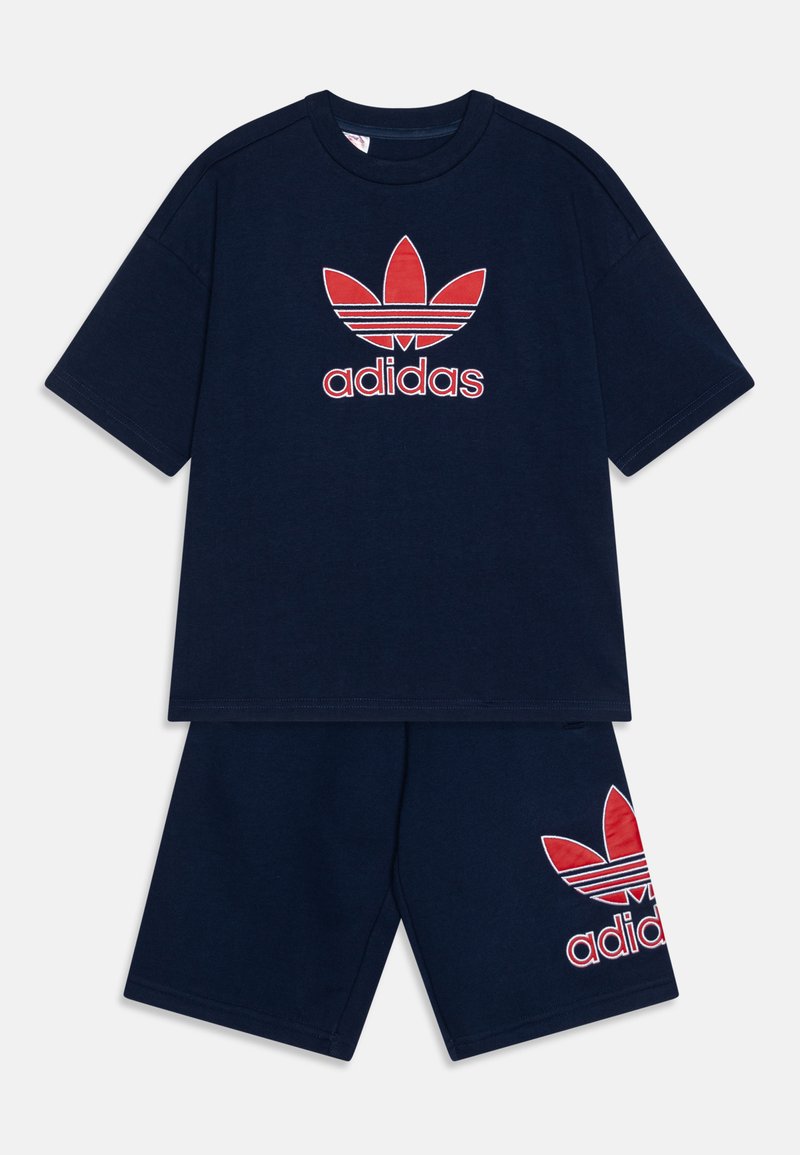 Set de tricou din bumbac navy și șorturi, cu un logo Adidas roșu cu un design de frunză pe piept și pe picior, mâneci scurte și croi lejer.