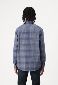 Camicia a maniche lunghe in plaid blu e grigio, con colletto button-down, orlo dritto e una morbida texture del tessuto con motivo a quadrati.