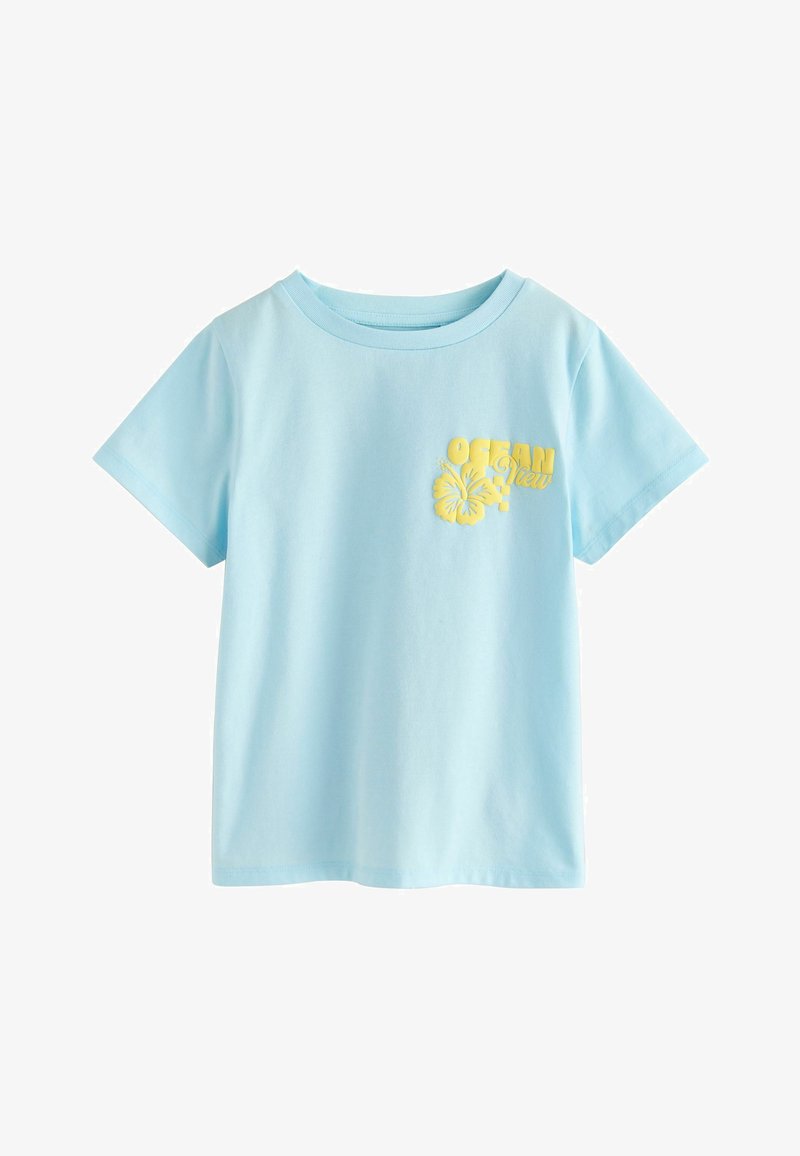 Camiseta de manga corta azul claro con texto amarillo "Ocean View" y un gráfico de flor de hibisco en el pecho izquierdo.