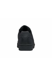 Černé tenisky s hladkým koženým svrškem, nízkým profilem, polstrovaným límcem a gumovou podrážkou. Minimalistický design, bez viditelných vzorů nebo akcentů.