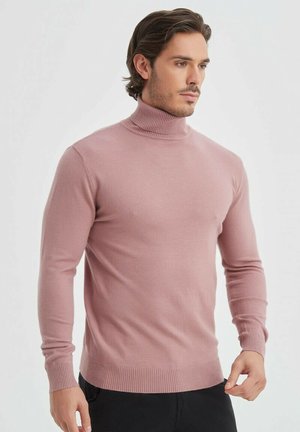 Pull à col roulé rose clair en tissu doux, avec des manches longues, des poignets côtelés et une coupe ajustée.