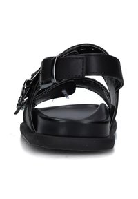 Sandali neri con cinturini in pelle regolabili, suola piatta e design con fibbia. L'interno presenta una texture liscia e dettagli minimi.