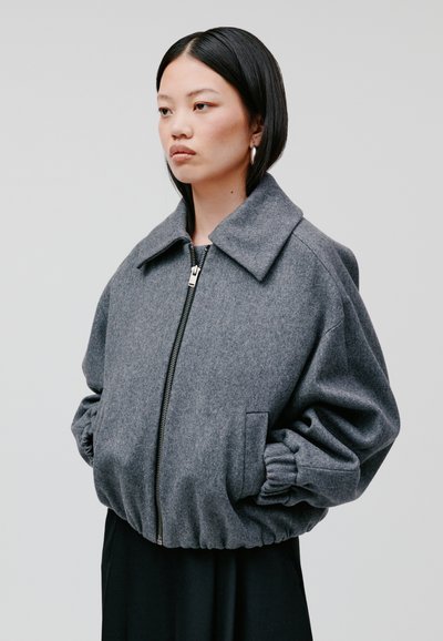 Graue Woll-Bomberjacke mit Kragen, Reißverschluss vorne und elastischen Bündchen. Enthält zwei seitliche Taschen und eine lockere Silhouette.